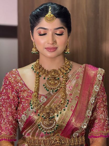 A close-up of a bride with a soft, peachy-pink eyeshadow look. This adds a touch of modern romance to her traditional South Indian attire.