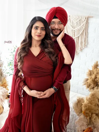 This lovely couple looks so elegant in coordinated deep red outfits. My boho setup with pampas grass and macrame provides a warm, natural backdrop for maternity portraits.