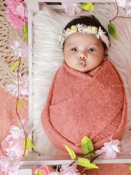 An adorable awake moment from the pink floral bed session, with the baby making a cute pouty face.