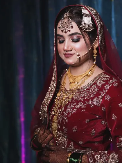 This bride looks absolutely serene. Her makeup features a classic winged liner, shimmery eyeshadow, and a perfectly set passa and nath.