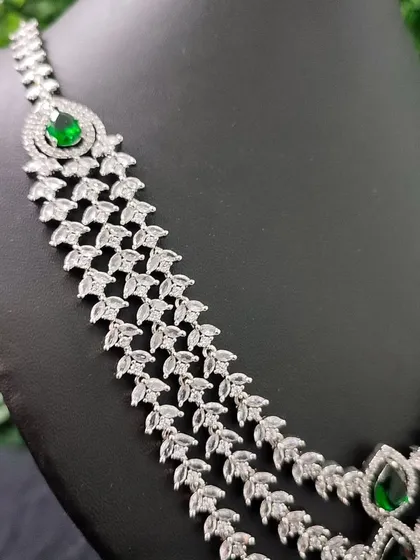 A close-up showing the cascading layers of leaf-shaped AD stones in this stunning green necklace.