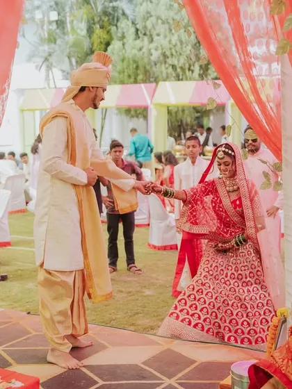 The couple holding hands as they walk through the decorated wedding aisle.