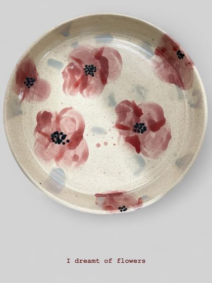 'I Dreamt of Flowers', a hand-painted plate with soft, impressionistic poppies. This piece is more about capturing a feeling than a realistic image, using gentle colors on a speckled clay body.