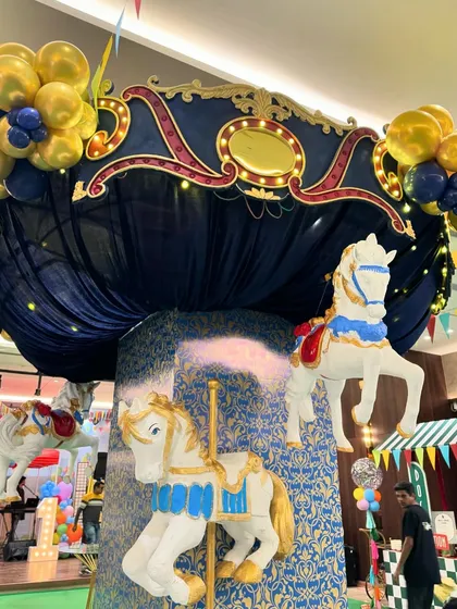 A Central Park-themed first birthday featuring a stunning carousel centerpiece, a candy floss cart, and a large pastel-colored soft play area for endless fun.