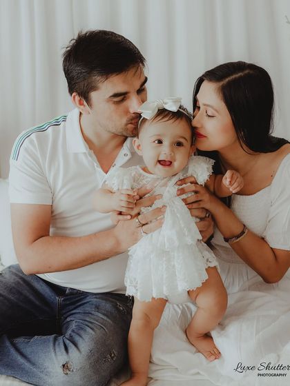 A beautiful, warm-toned photo of a family sharing kisses and cuddles. The soft lighting and genuine emotion make this a truly special portrait.