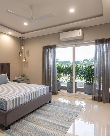 Another view of a guest bedroom, this time with a more neutral palette and a focus on the view from the large glass doors.