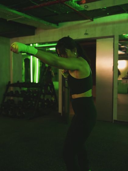 Feel the intensity during a STRIKE boxing class. The green lighting sets the tone as members practice their jabs and footwork, building speed and power in a motivating group environment.