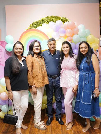 A happy family gathers for a photo at the butterfly-themed party. We love celebrating these special family milestones.