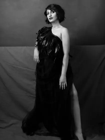 The black and white version of the feathered gown portrait. It enhances the drama and texture of the dress, creating a timeless and high-fashion look.
