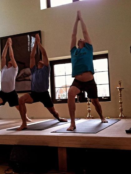 Senior practitioners demonstrating Virabhadrasana I (Warrior I) at the Greenwich opening. It was a celebration of community, dedication, and the spiritual journey of yoga.