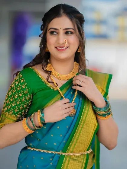 Adjusting her jewelry, this shot highlights the beautiful details of the look, from the makeup to the traditional accessories.