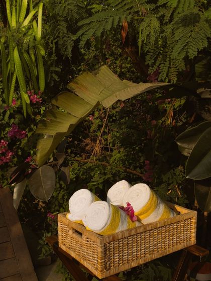 A basket of fresh, rolled towels ready for guests by the pool, a small touch of thoughtful hospitality.