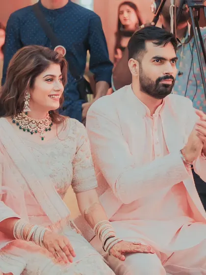 The couple enjoying the performances at their Mehendi, looking elegant in their coordinated pastel outfits.