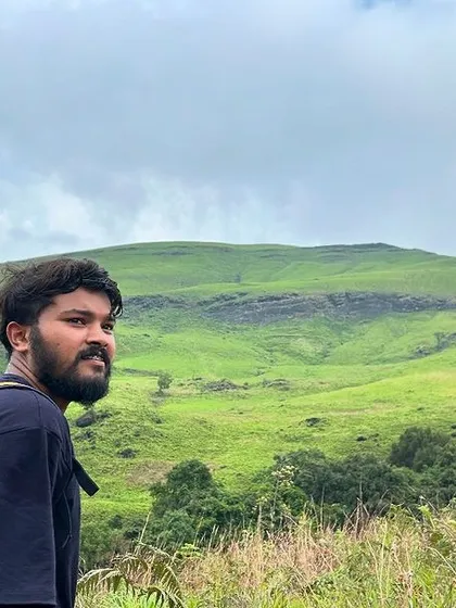 A trekker taking in the view of the green hills of Kalasa.