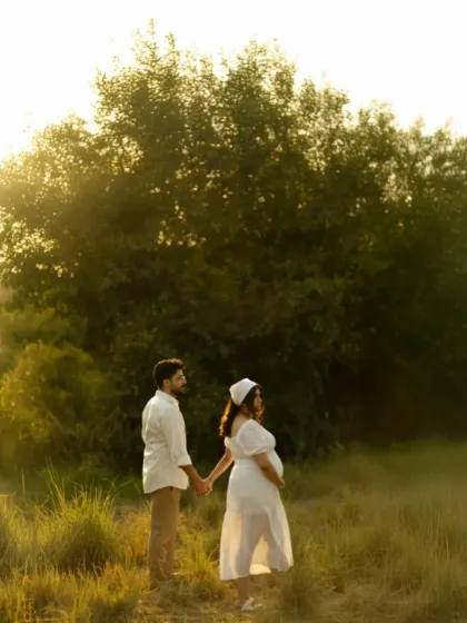 A walk through a misty, sunlit field. The couple holds hands, surrounded by a dreamy haze and the warm glow of the sun, creating a magical and romantic atmosphere.