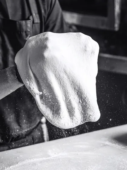 A playful dance of flour, fun, and fantastic flavors. Tossing the dough is a skill that takes practice, and it's mesmerizing to watch.