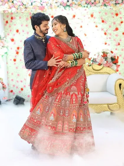 A fairytale moment from her reception. The dramatic lighting and smoke effect highlight her stunning red lehenga and flawless makeup.