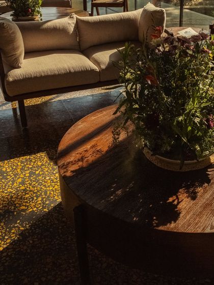 Dappled sunlight falls across the terrazzo floor and a modern sofa in our lounge, a perfect spot for an afternoon pause.