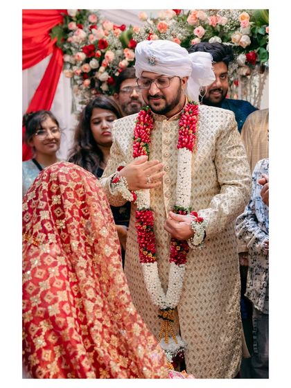 The groom stands with his bride, who is covered by the dupatta. This is a key moment in the Nikah ceremony, captured with a focus on the couple.