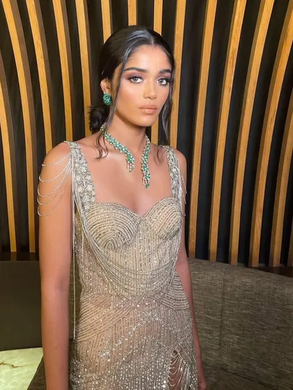 A close-up of a modern, glamorous look with a beaded gown. The makeup is soft and romantic, with a focus on a peachy glow.