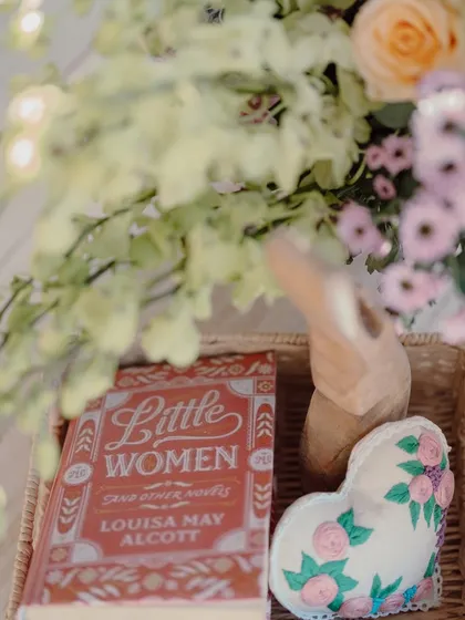 A copy of "Little Women" and other curated props that add a personal and literary touch to the decor.