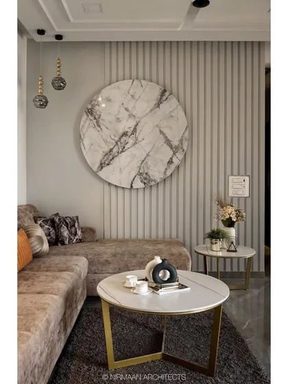 A close-up of the living area at our KVK Camellia project. The circular marble art piece is backlit to create a warm glow, complementing the fluted wall paneling and plush sofa for a contemporary look.