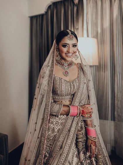 A full-length portrait of a bride in her room before the ceremony. She looks radiant and ready for her big day.