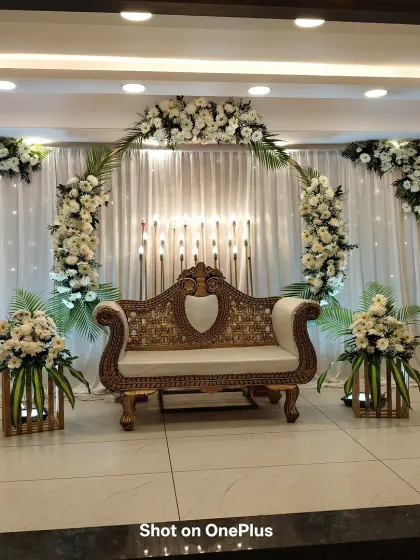 A beautiful stage decoration for a Tonsure Ceremony, which can also be used for an engagement. The white floral arch and golden sofa create a clean and grand look.