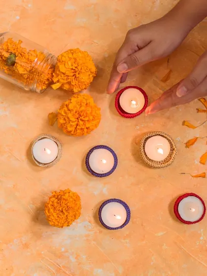 A top-down view of our simple crochet diya jackets being arranged for Diwali. These colorful rings are an easy way to dress up simple tea lights.