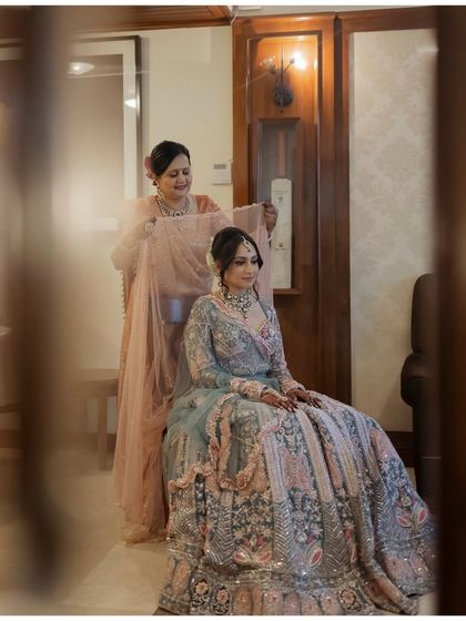 A touching moment between a bride and her mother. The mother helps adjust the veil, a gesture of love and care captured in a quiet, intimate portrait.