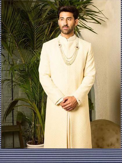 My off-white sherwani, styled with a traditional multi-layered pearl necklace. The simplicity of the garment allows for accessorizing, making it a versatile choice for a modern Maharaja.