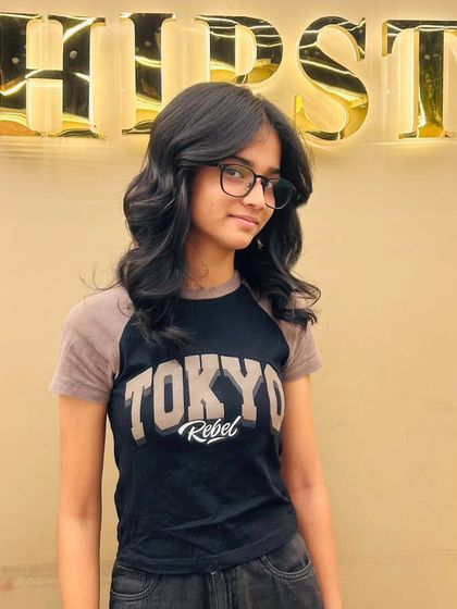 A happy client with her new layered haircut, a style that is both trendy and timeless.