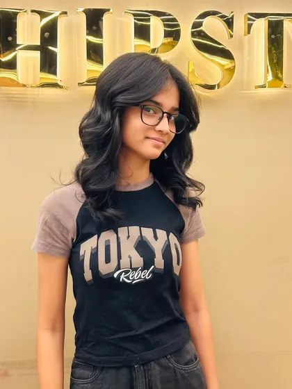 A happy client with her new layered haircut, a style that is both trendy and timeless.