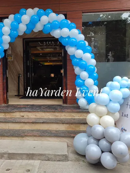 A similar blue and white balloon arch at a banquet hall entrance, paired with a custom welcome sign.