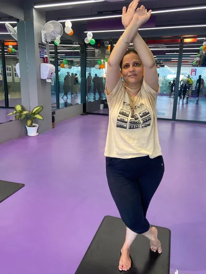 A member demonstrates a variation of the Eagle Pose with arms raised, a modification we teach to accommodate different levels of shoulder flexibility.