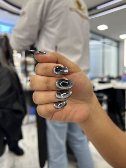 A dark, smoky cat-eye nail set created by a student. This demonstrates their skill with trendy and advanced effects.