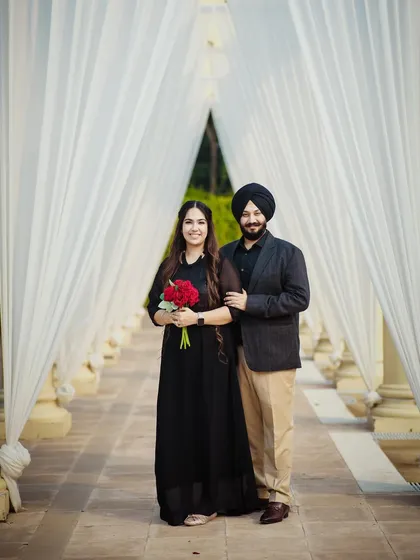 A simple and elegant pre-wedding photo in a beautiful white colonnade. The bride holding a bouquet of red roses adds a perfect pop of color.