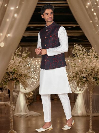 A simple white kurta paired with a navy and red printed Nehru jacket, a classic and sharp look.