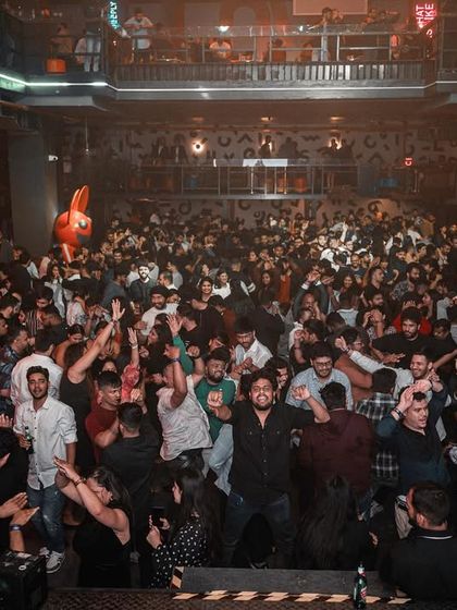 The entire crowd at the corporate event, hands in the air.