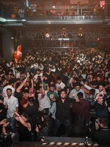 The entire crowd at the corporate event, hands in the air.