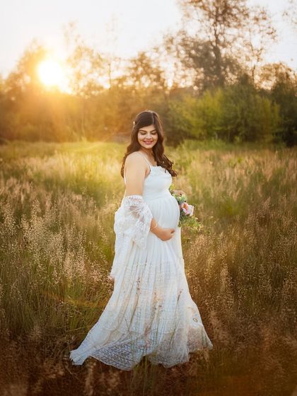A joyful, candid moment of the mom to be smiling in a sunlit field. This photo perfectly captures the happiness and beauty of pregnancy.