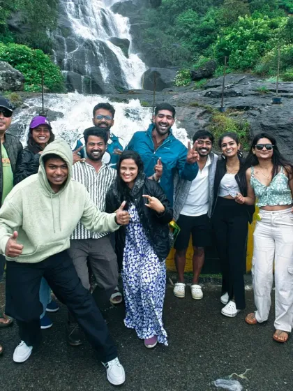 The group enjoying the spray from a waterfall in Munnar. These moments of pure fun are what our trips are all about.