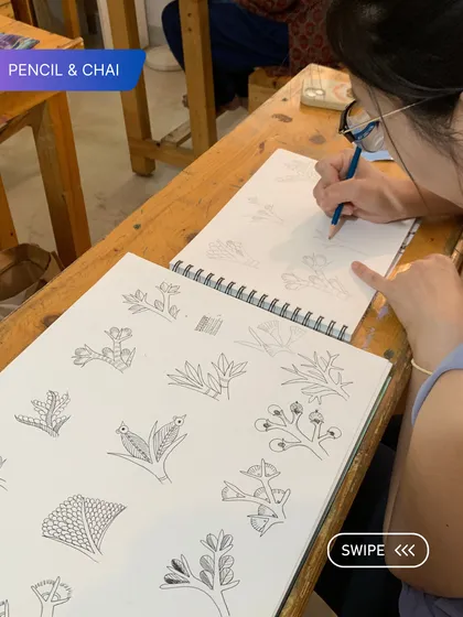 Here, a student practices various Gond art motifs and patterns in her sketchbook. This foundational work is key to building a strong artistic vocabulary.