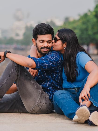 A sweet and spontaneous kiss on the cheek during a relaxed outdoor session, highlighting the couple's affectionate bond.