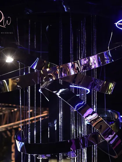 A futuristic, metallic sculpture with hanging crystals, used as a centerpiece for a modern-themed event.
