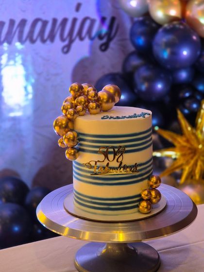 Another view of the '50 & Fabulous' cake, showing how the golden decorations catch the light.