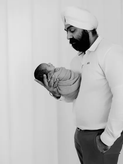 A powerful black and white shot of a father holding his newborn. The strong composition and emotional content make this a striking and memorable family portrait.