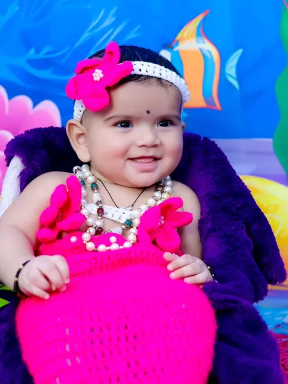 A sweet close-up of the smiling baby mermaid in her pink costume.