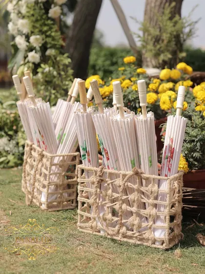 Baskets of beautiful white paper umbrellas, a thoughtful and practical detail for a sunny outdoor wedding.