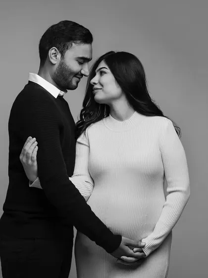 A sweet moment of connection between an expecting couple. This black and white portrait captures the quiet look of love and excitement shared between them.